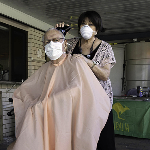 Ben Watson's photograph of Heather Strong cutting Bob Strong's hair at home.