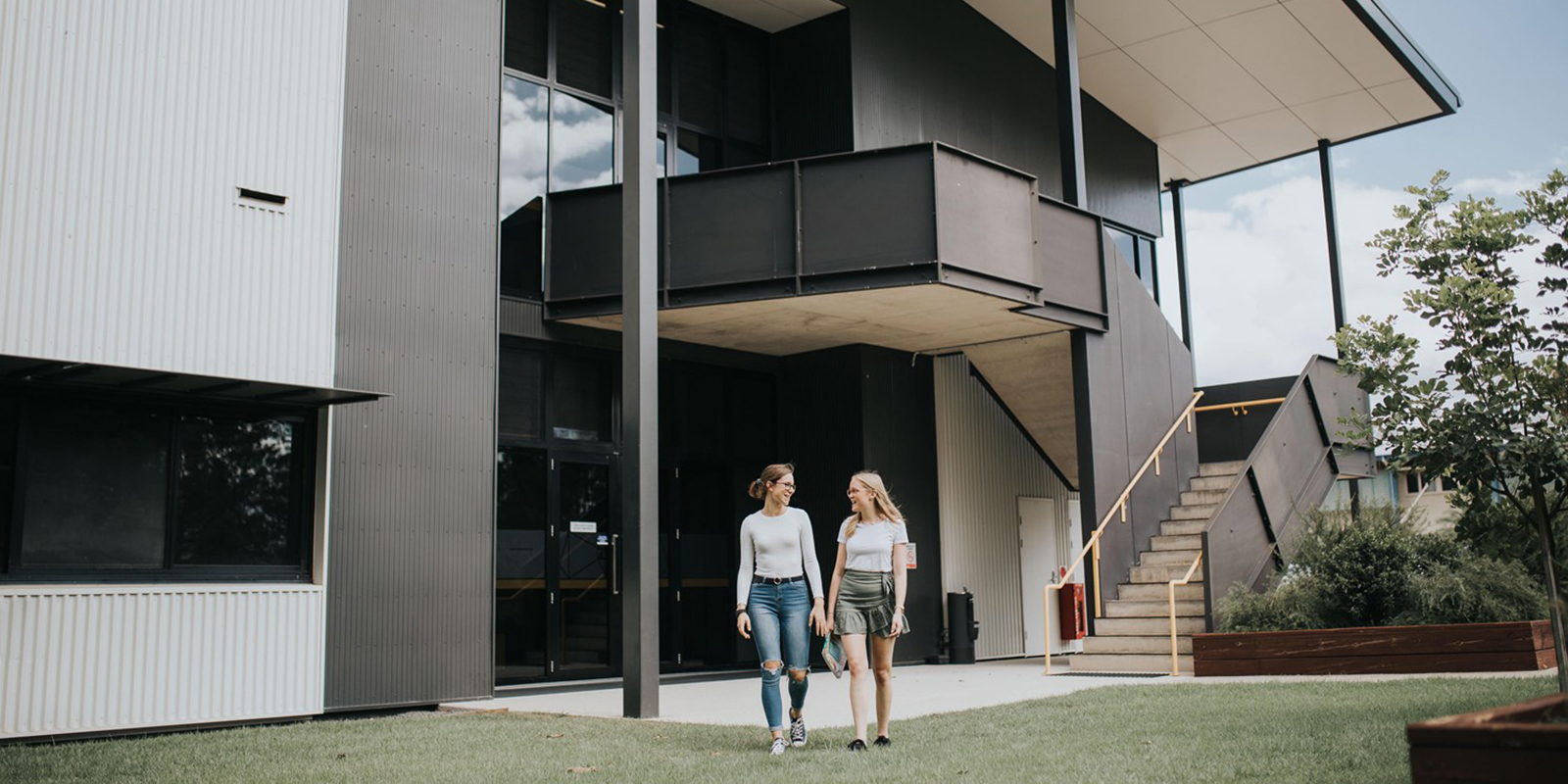 two female students in front of USC Gympie building