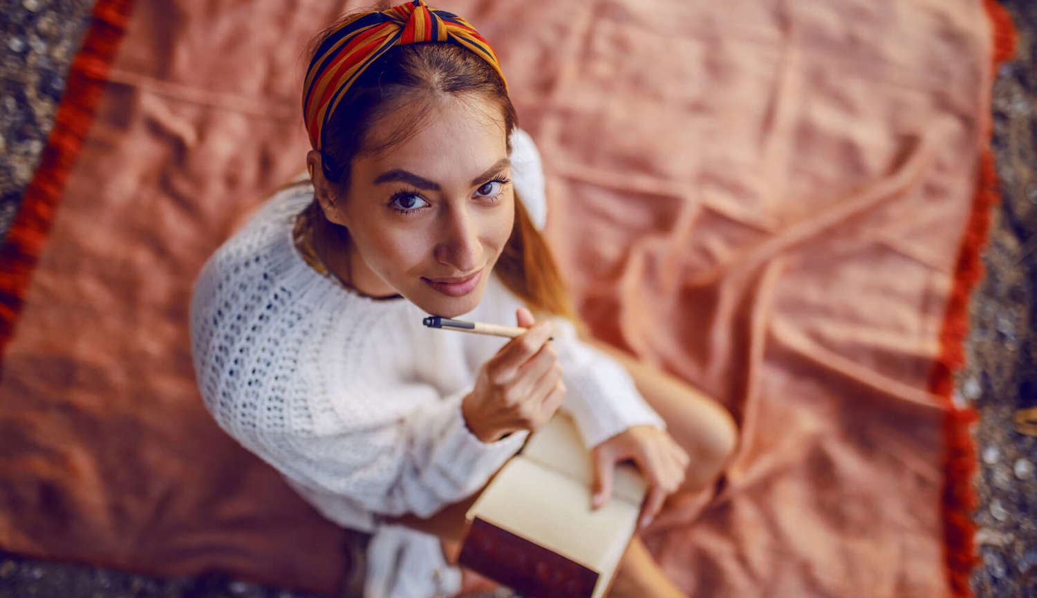 women writing while smiling at camera