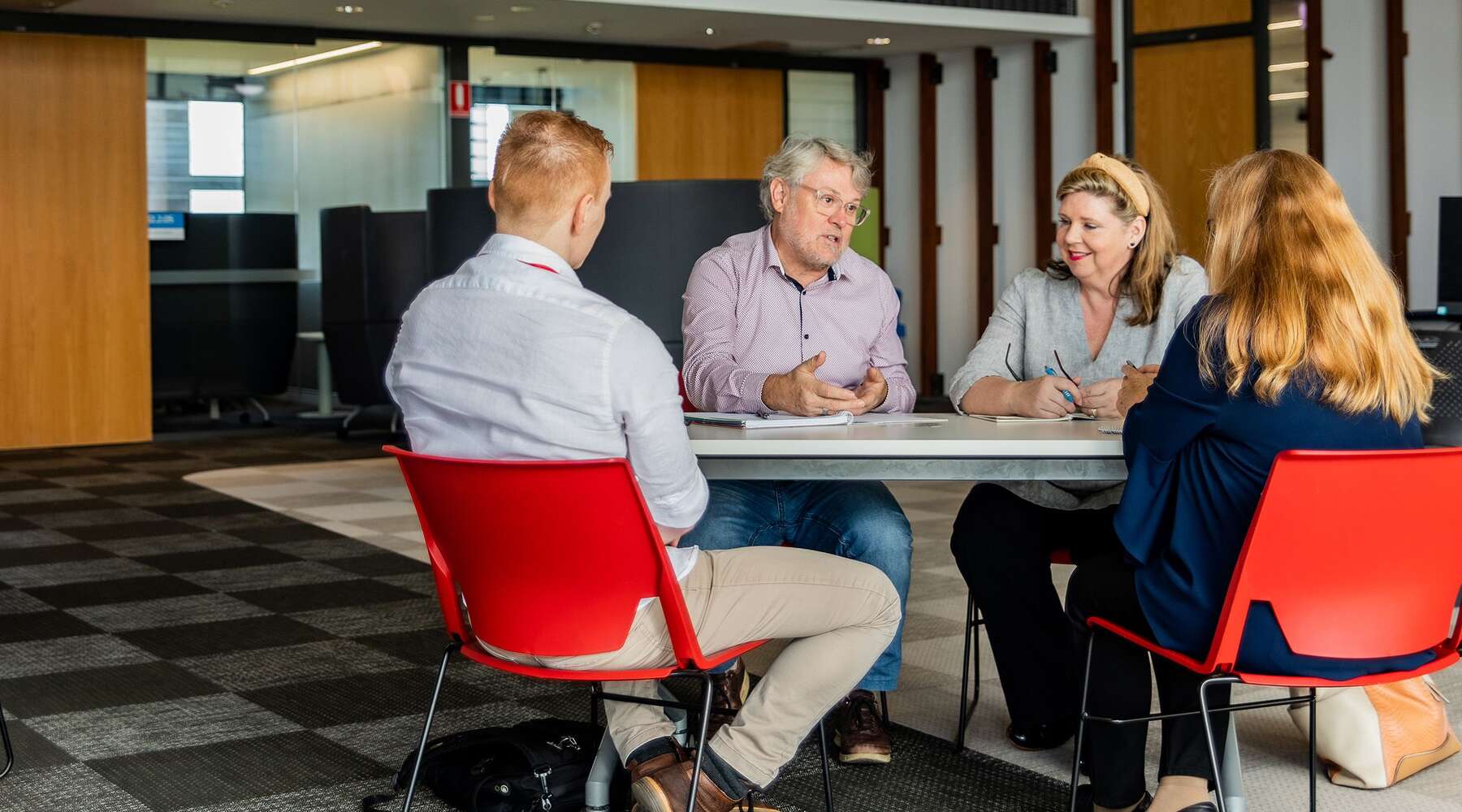 John Rosenberg talking with colleagues