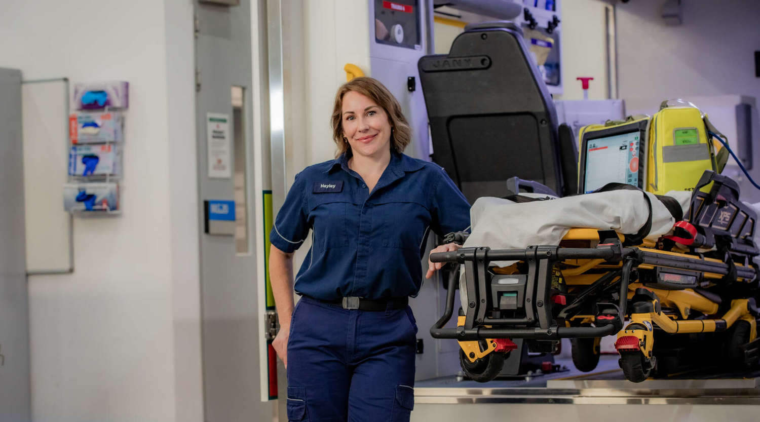 Paramedic Student Hayley Mailman standing in front of ambulance