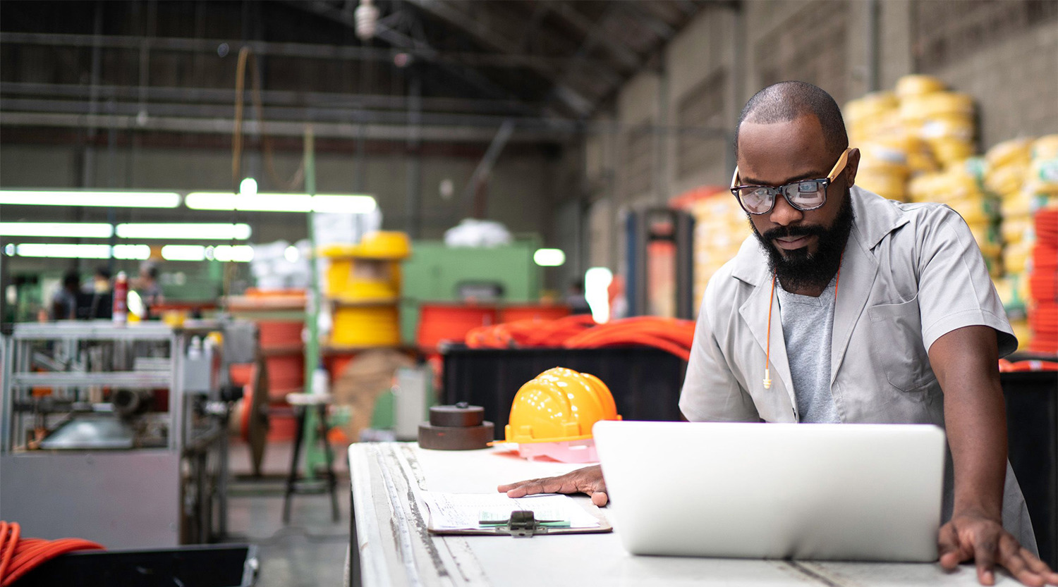 Engineer working at the factory using laptop