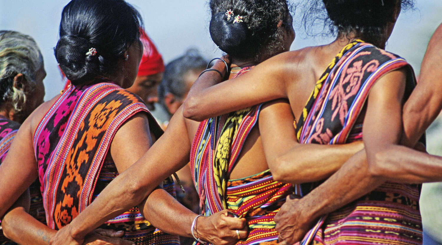 Celebration of Indepedence in East Timor, women wear cultural dress and stand arm in arm 