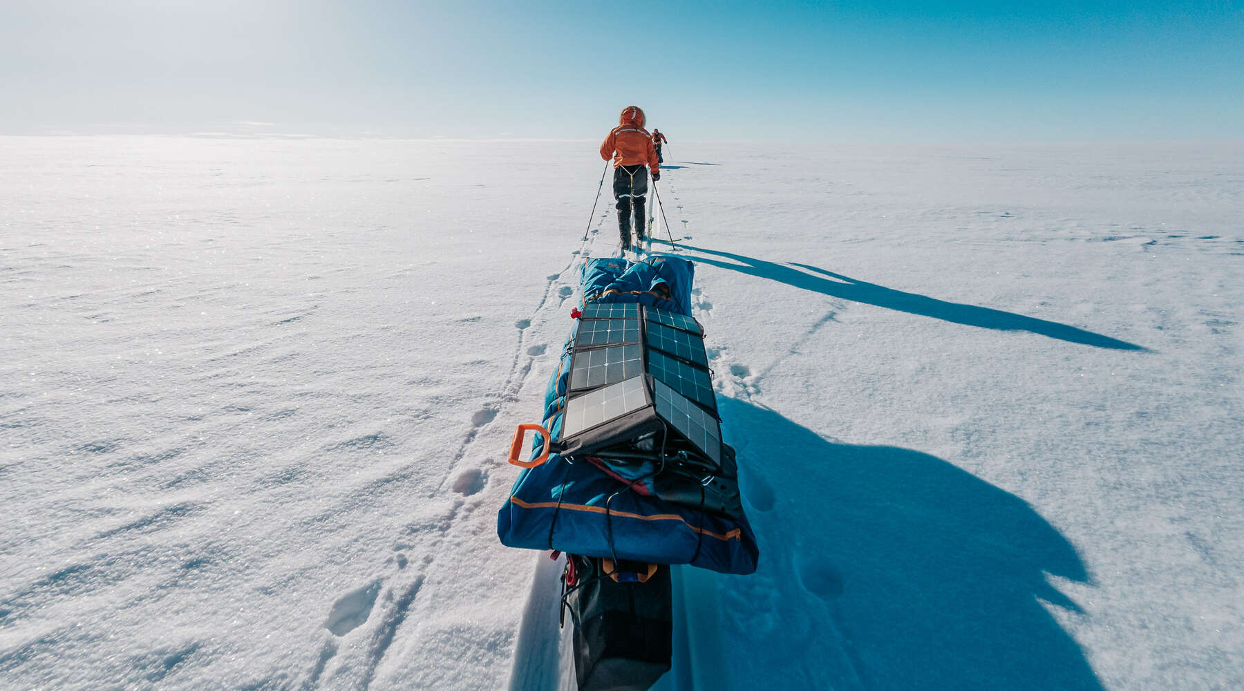 person pulling large sled of equipement