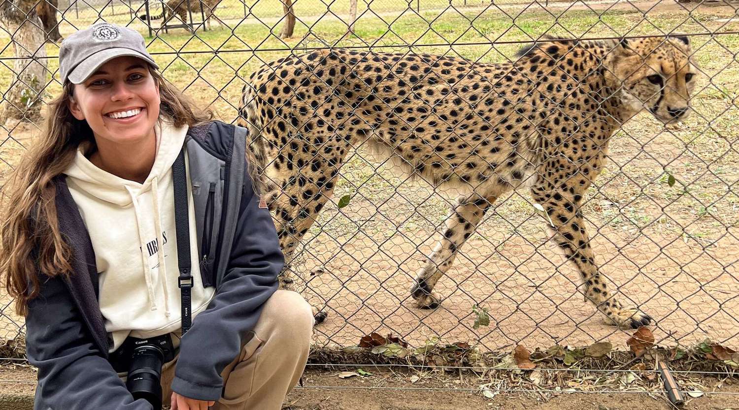 Bella Chaseling posing in front of a cheetah 