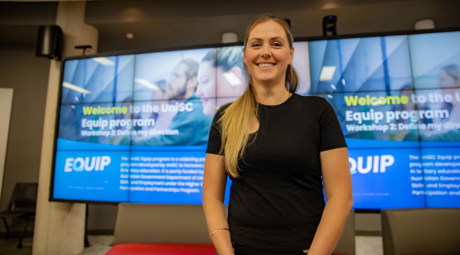 Former UniSC's Equip program participant Elizabeth Schahinger with long, blonde hair tied in a ponytail is looking at the camera