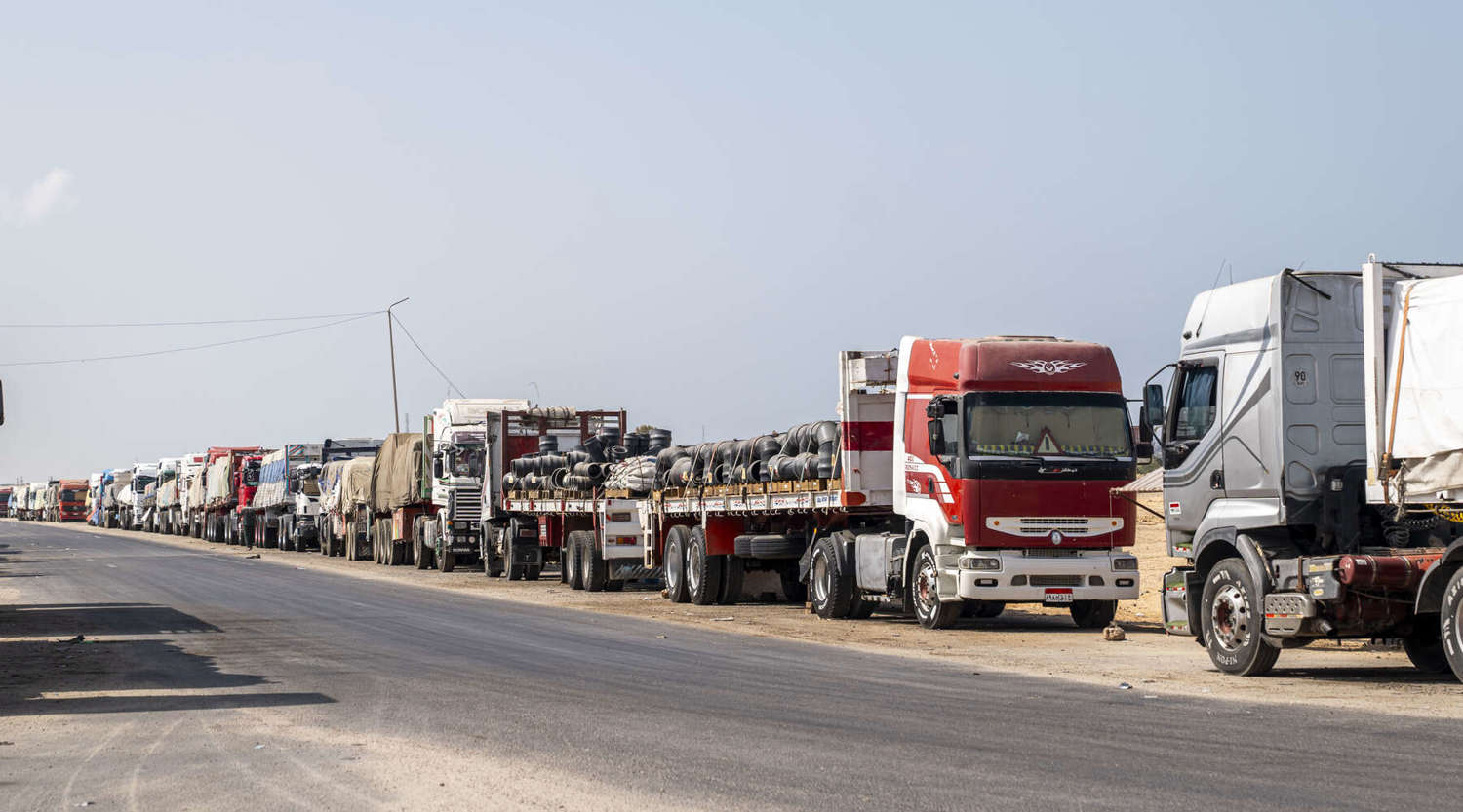 Trucks with aid destined for the Gaza Strip are parked on the side of the road 